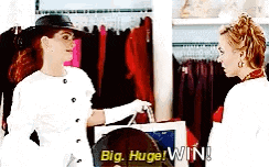two women are standing next to each other in a store and one of them is holding a bag that says big huge win !