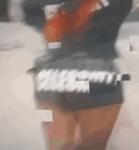 a blurry picture of a person standing next to a table with a bottle of alcohol in the background .