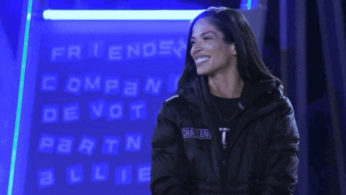 a woman in a black jacket is smiling in front of a sign that says " friends companion devotion "