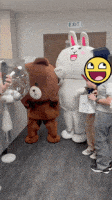 a group of mascots are posing for a picture in front of an exit sign