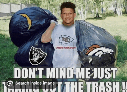 a man in a raiders t-shirt is holding a trash bag