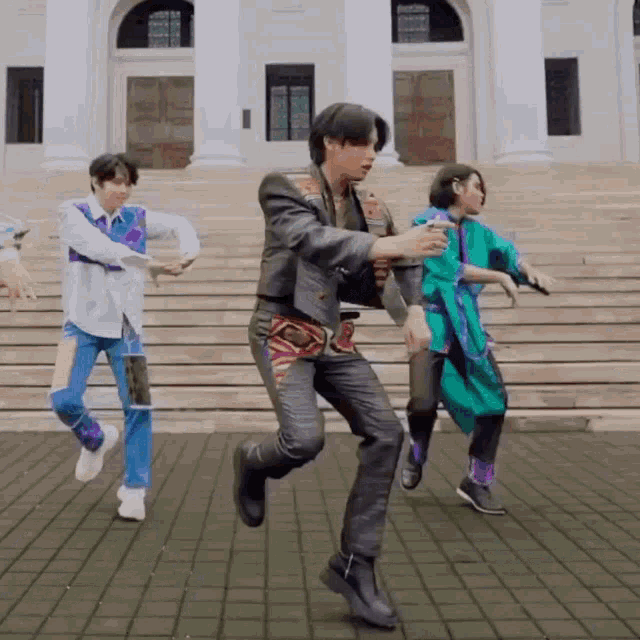 a group of people are dancing in front of a building with stairs