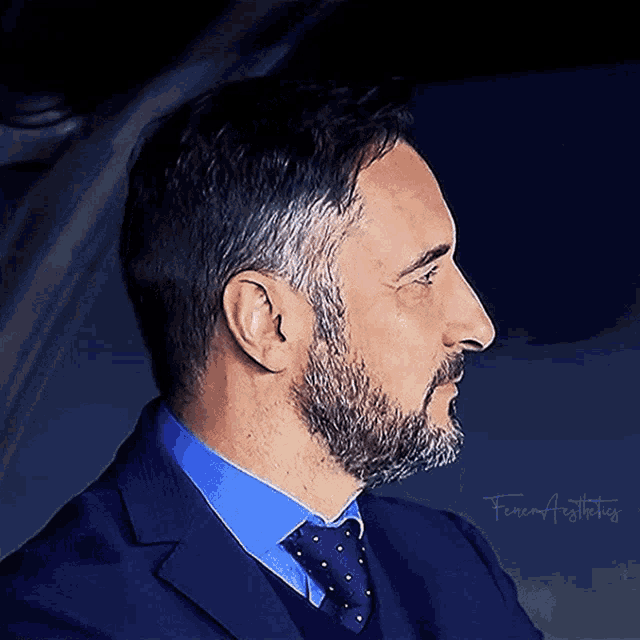 a man with a beard is wearing a suit and tie with the name fenerbahce written on the bottom