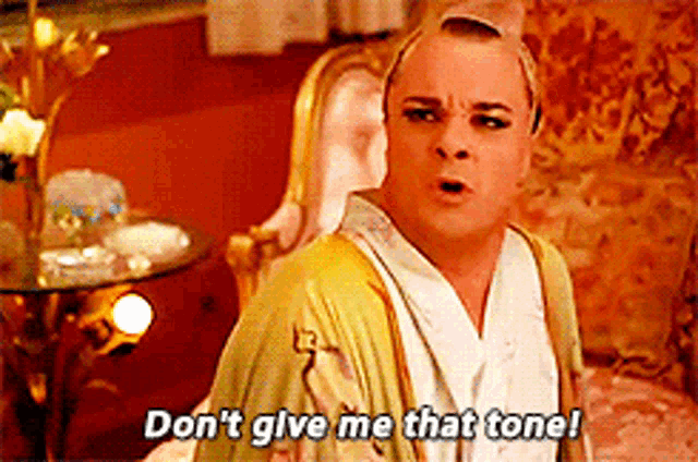 a man in a green robe says " don 't give me that tone "