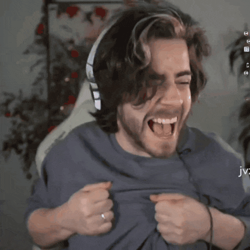 a man with a beard is laughing with his tongue out