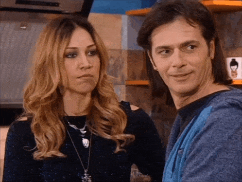 a man and a woman are standing next to each other in a kitchen