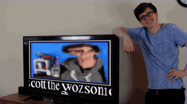 a man stands in front of a tv screen that says cott the wozsonic
