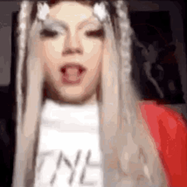a close up of a person wearing a wig and a t-shirt with the letter n on it .