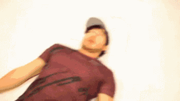 a man wearing a hat and sunglasses is making a funny face .