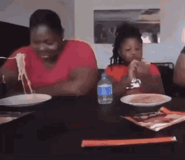 a group of people are sitting at a table eating food .