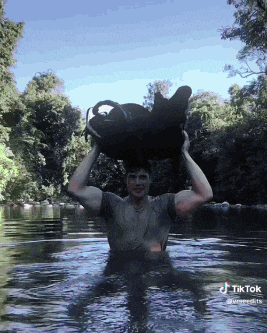 a man is in the water holding a bag over his head and a tiktok logo is visible in the corner