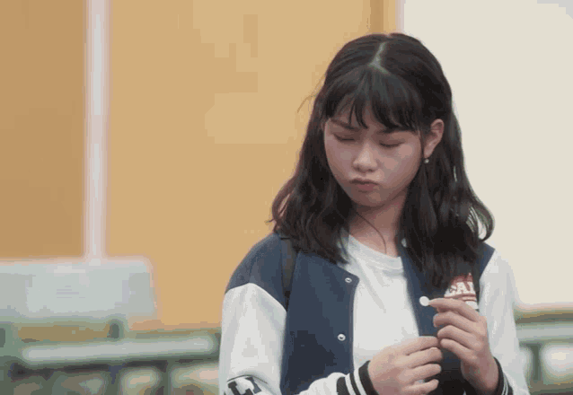 a girl wearing a blue and white jacket with the word sal on the sleeve