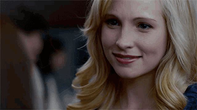 a woman with blonde hair and blue eyes smiles for the camera