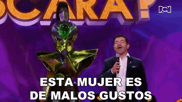 a man singing into a microphone with the words esta mujer es de malos gustos on the bottom