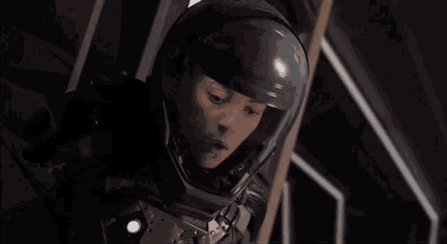 a woman in a space suit and helmet is standing in a room .
