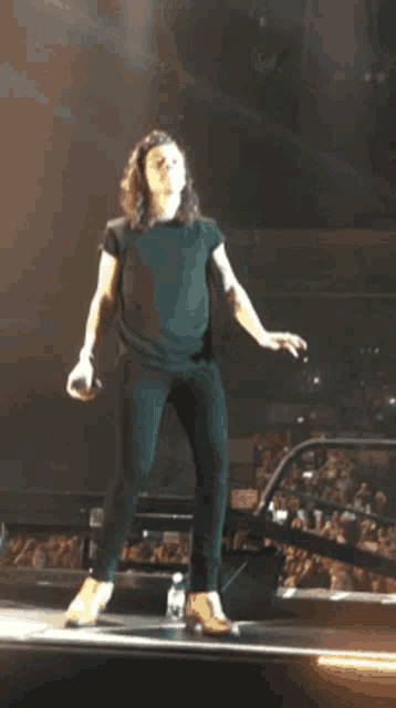 a man is dancing on a stage with a microphone