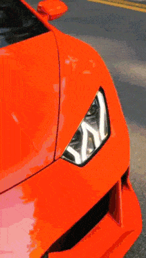 a close up of a red sports car 's wheel on a road