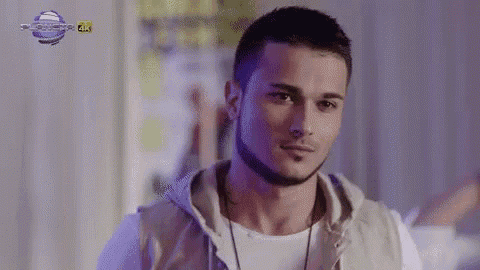 a young man with a beard is wearing a hoodie and a white shirt .