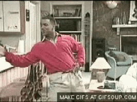 a man in a red shirt is flying through the air in a living room