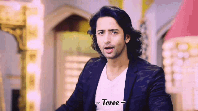 a man is wearing a white shirt and a black jacket and says toree