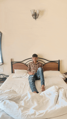 a young man laying on a bed with his legs crossed