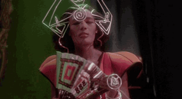 a woman is wearing a futuristic costume with a glowing headpiece .