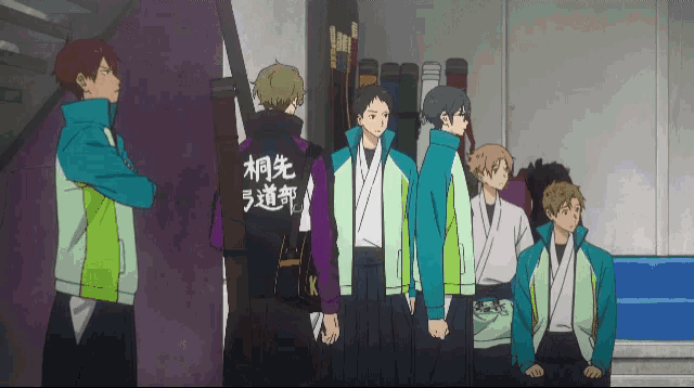 a group of boys are standing in a line with one wearing a shirt that says " k " on it