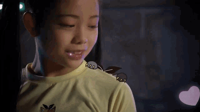 a girl with a cartoon cat on her shoulder looks down