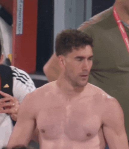 a shirtless man stands in front of a sign that says ' emergency exit ' on it