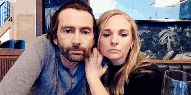 a man and a woman are sitting next to each other in a restaurant .