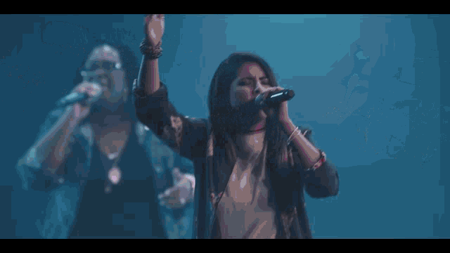 a group of people singing on a stage with a sign that says you are the strength of my heart
