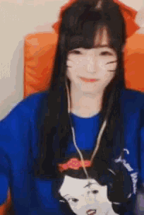 a girl with long hair is wearing a blue shirt