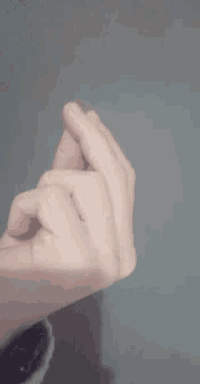 a person 's hand is making a heart shape with their fingers .