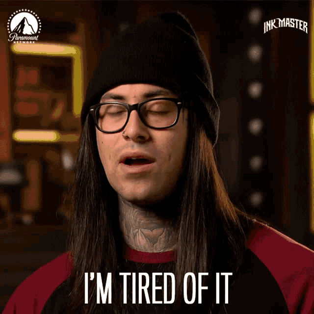 a man wearing glasses and a beanie says " i 'm tired of it "