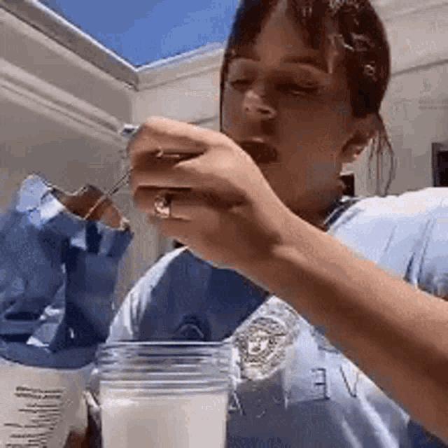 a woman is drinking milk from a glass while eating a chocolate bar .