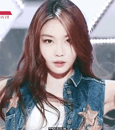 a close up of a woman wearing a denim vest