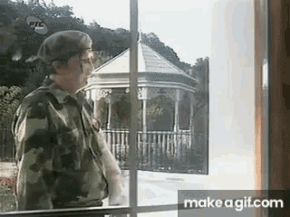a man in a military uniform is standing in front of a gazebo .
