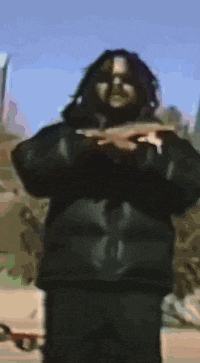 a man with dreadlocks is wearing sunglasses and making a funny face .