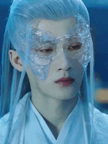 a man with long white hair and a mask on his face .