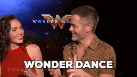 a man and a woman are standing next to each other in front of a sign that says wonder dance .