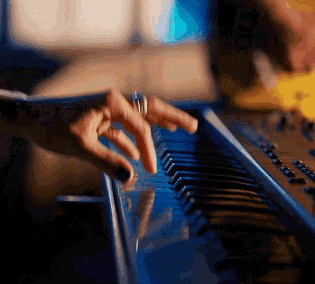 a person with a ring on their finger is playing a keyboard