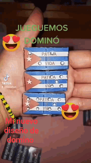 a hand holding a stack of dominoes with the words jueguemos domino