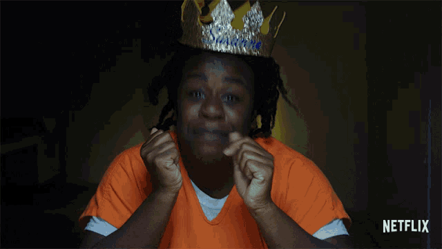 a woman wearing an orange shirt and a crown with the name suzanne on it