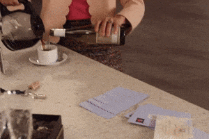 a woman pouring a bottle of wine into a cup