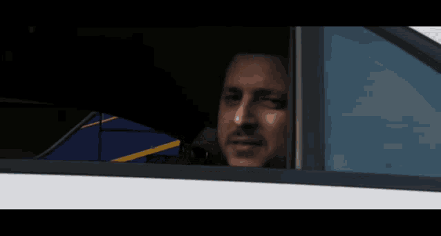 a man in a car looks out the window