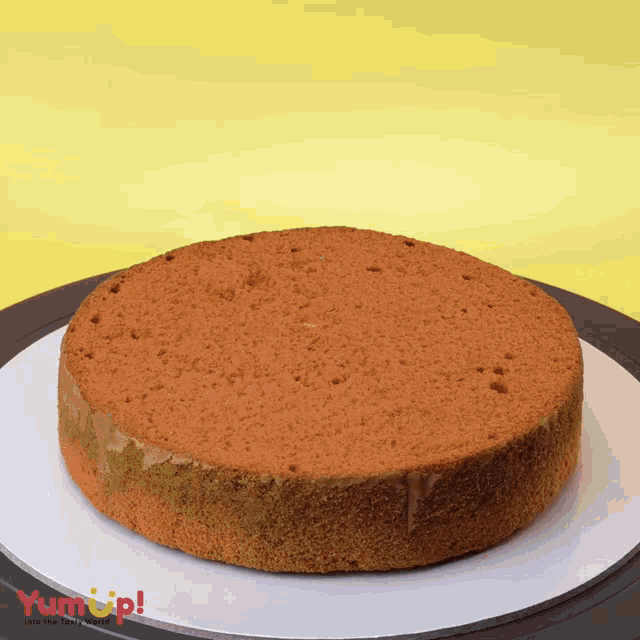 a cake on a white plate that says yum up on the bottom