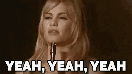 a woman is holding a gun and saying yeah yeah yeah .