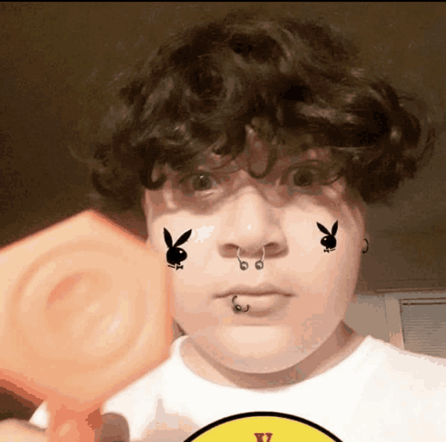 a person with bunny stickers on their face and a yellow v on their shirt