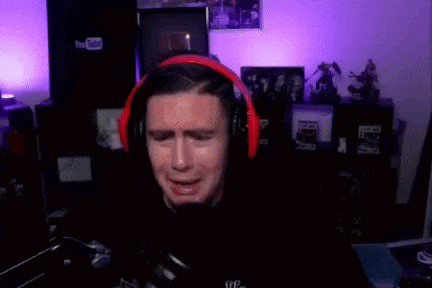a man wearing headphones is crying in front of a microphone in a room .