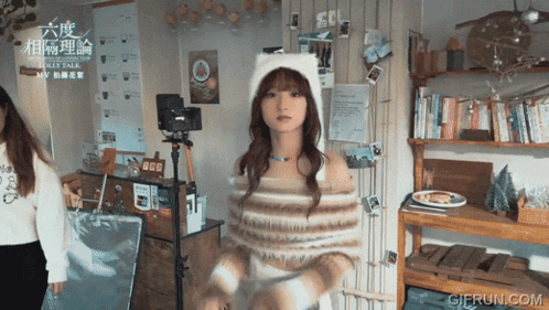 a girl wearing a cat hat is in a room with a sign that says ' lunar talk ' on it